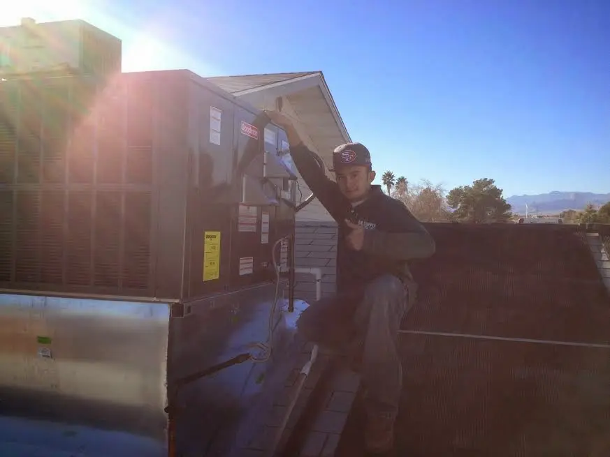 HVAC technician performing AC Tune-Up on a rooftop unit in Monessen